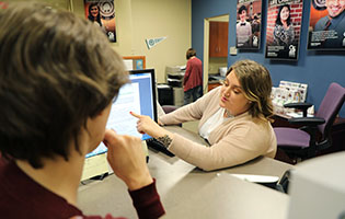 A Woman Pointing at a Computer Screen