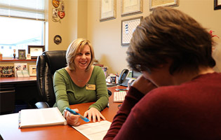 Woman Sitting Across from a Student