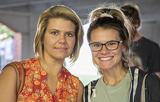 White mother and young adult daughter smiling